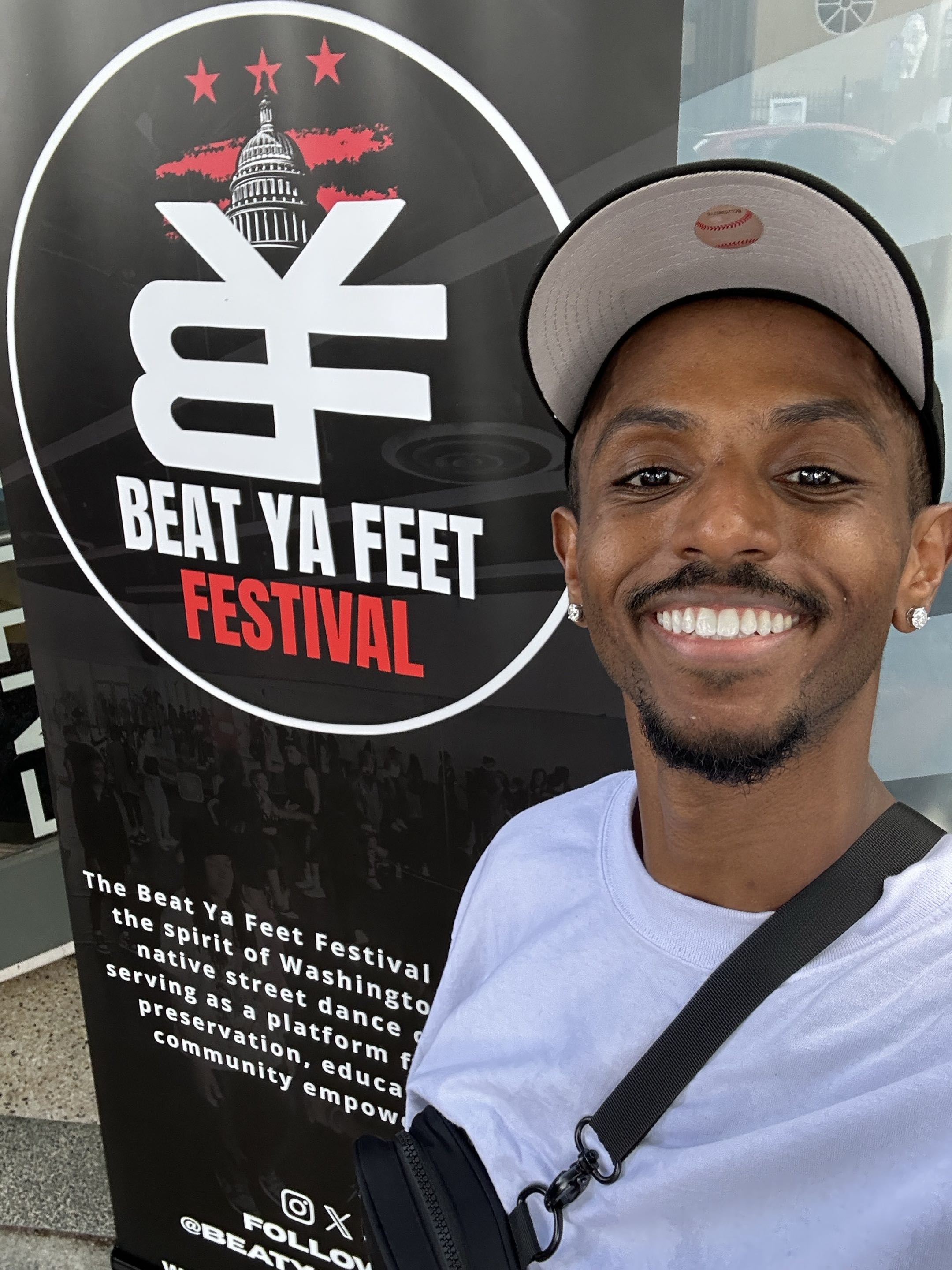 Meni selfie near the Beat Ya Feet Academy Festival sign, June 14 2026.