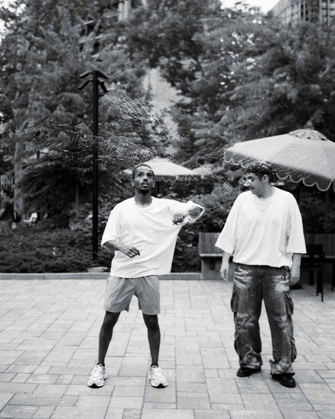 Meni teaching dancer Inca the Beat Ya Feet style at a DC street photographer meetup, July 2026.